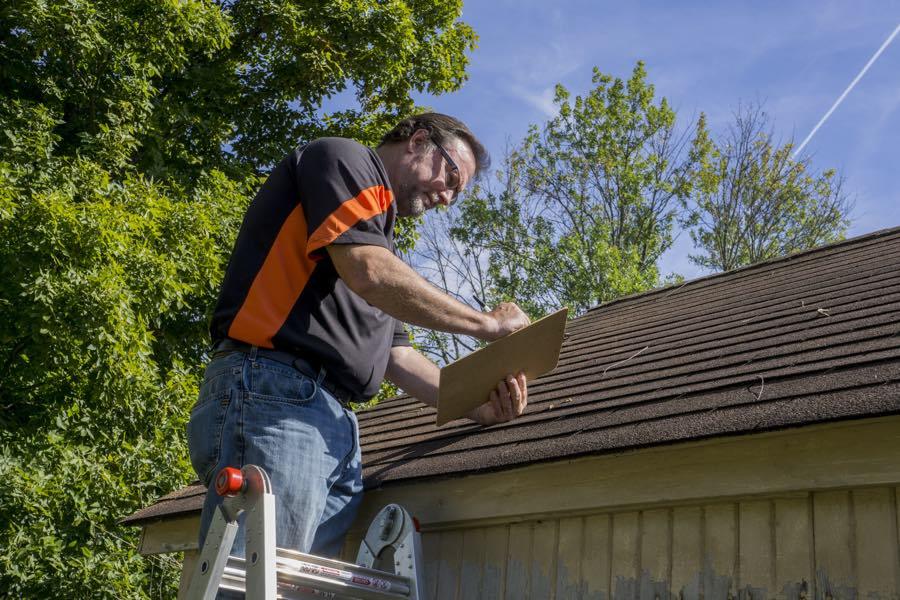 A Resident tries to find a leak on the roof of his house